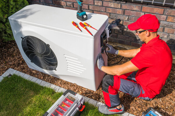 Techniker installiert Wärmepumpe Techniker installiert Wärmepumpe
